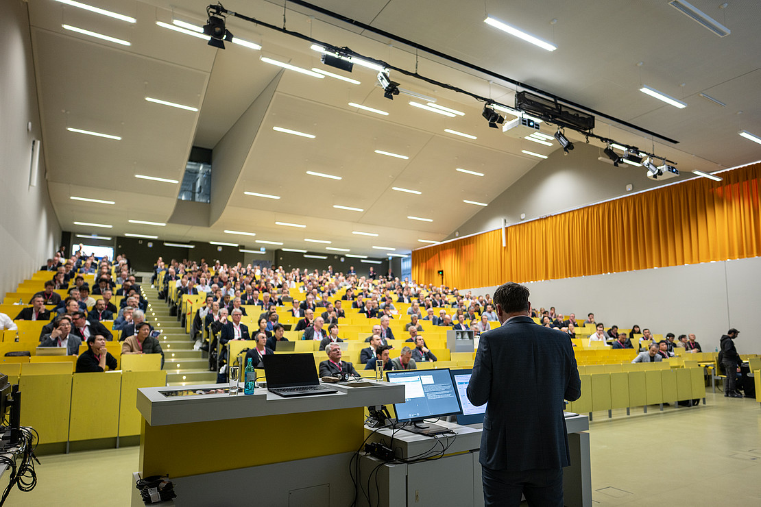 Speaker presenting to a full lecture hall